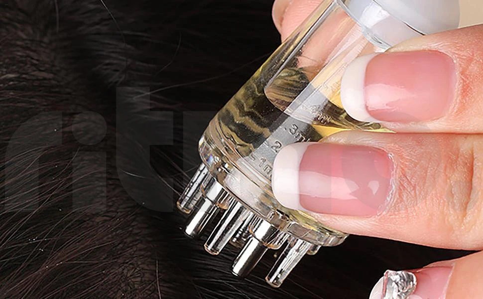 Aplicador manual transparente para cuero cabelludo con puntas metálicas dosificadoras y escala de medición de 1 a 3 ml visible en el cuerpo del recipiente.