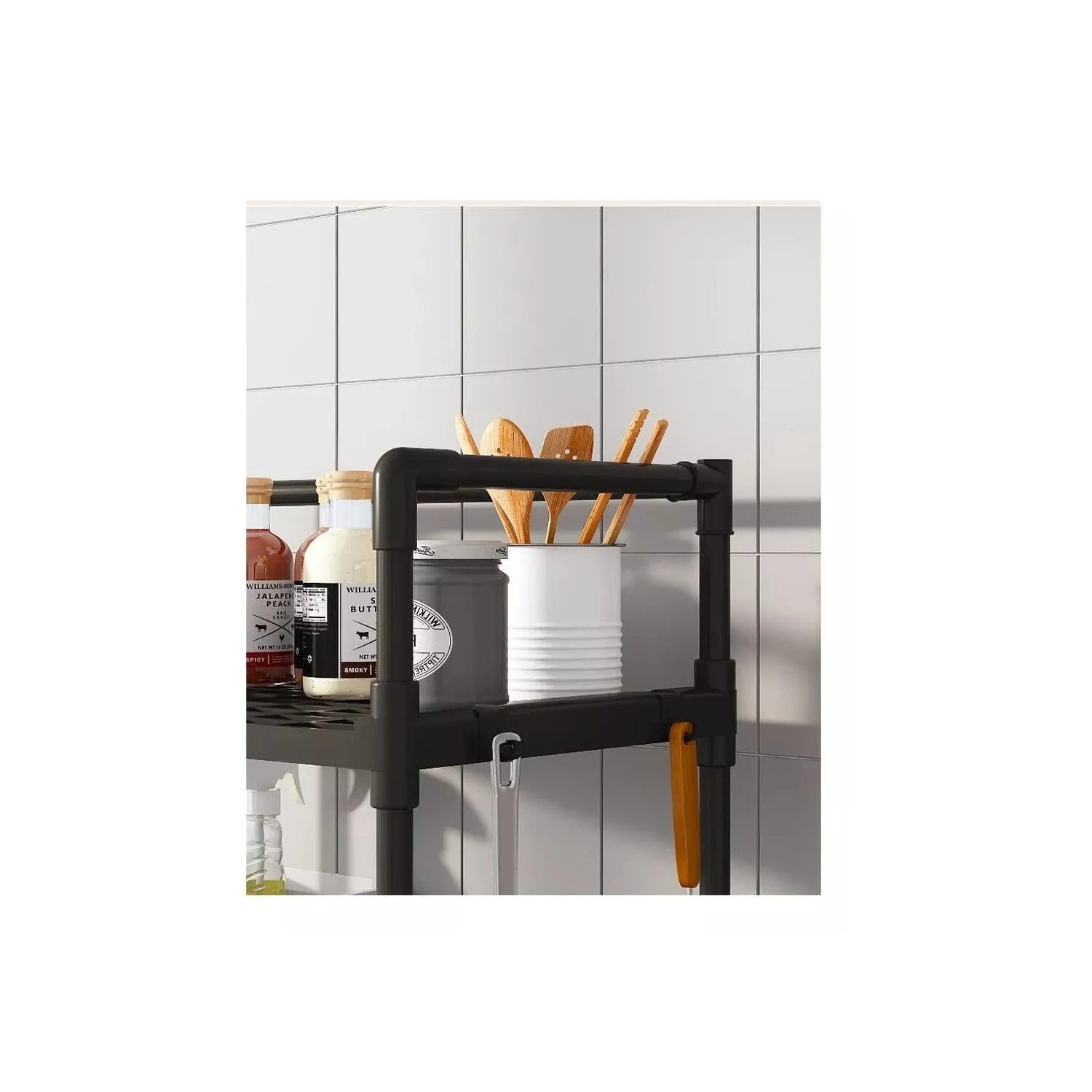 Estante organizador negro para cocina con botellas, utensilios y tarro blanco.