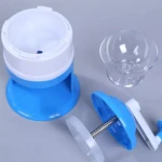 Triturador de hielo manual azul y blanco con manivela, recipiente transparente y bol pequeño.