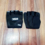 Guantes negros sin dedos, estilo ciclismo, con logo MSC y detalle reflectante, sobre suelo de madera.
