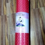 Tapete de yoga rojo tejido, enrollado, con diseño ecológico y figura de practicante.