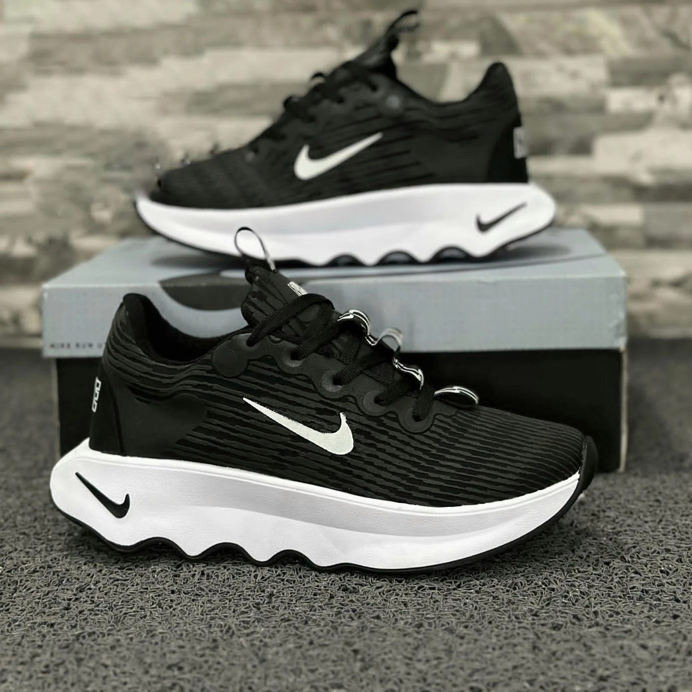 Zapatillas Nike Cabello negras con suela blanca ondulada, detalle Swoosh blanco y textura lineal.