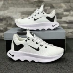 Zapatillas Nike blancas con detalles negros y suela ondulada, sobre caja de presentación.