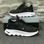 Zapatillas Nike negras con suela blanca ondulada, diseño moderno y detallado.