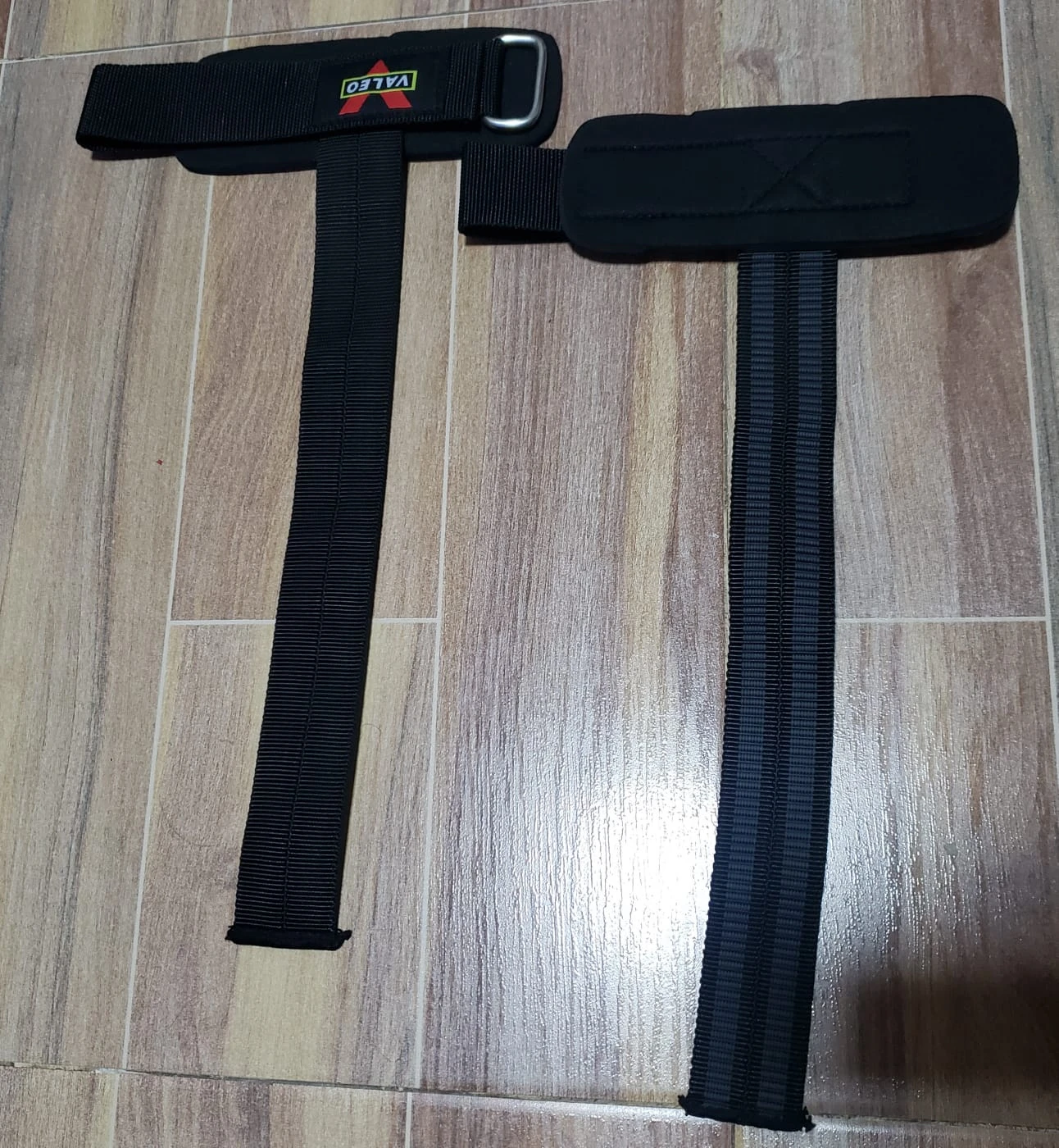 Muñequeras de gym Valeo negras con agarre reforzado para levantamiento de pesas.