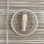 Tapa blanca con bombilla transparente para termo Stanley, vista superior, sobre fondo texturizado madera.