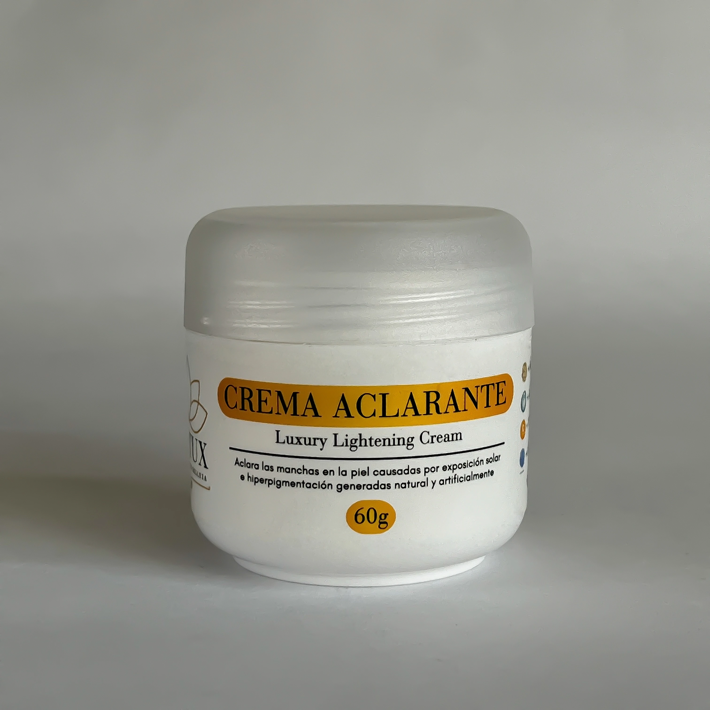 Envase blanco de 60g de crema aclarante Lotux, con tapa translúcida y etiqueta naranja que detalla su función contra manchas y pigmentación.