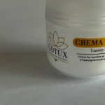 Envase blanco de Crema Lotux, con logo de flor dorada y etiqueta que destaca su función para aclarar manchas e hiperpigmentación de la piel.