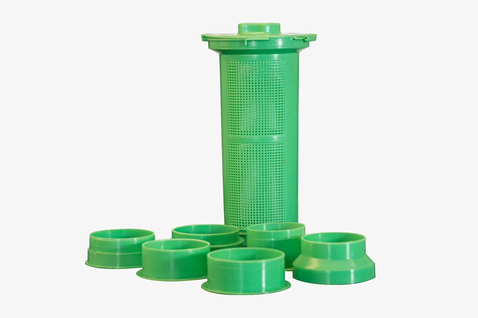 Filtro extractor verde para licuadora, cilíndrico con rejilla, e incluye 6 acoples adaptadores.