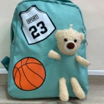 Mochila escolar azul con diseño de baloncesto y osito peluche.
