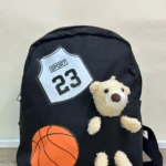 Mochila escolar negra con apliques de oso peluche, balón de baloncesto y diseño deportivo "SPORT 23".