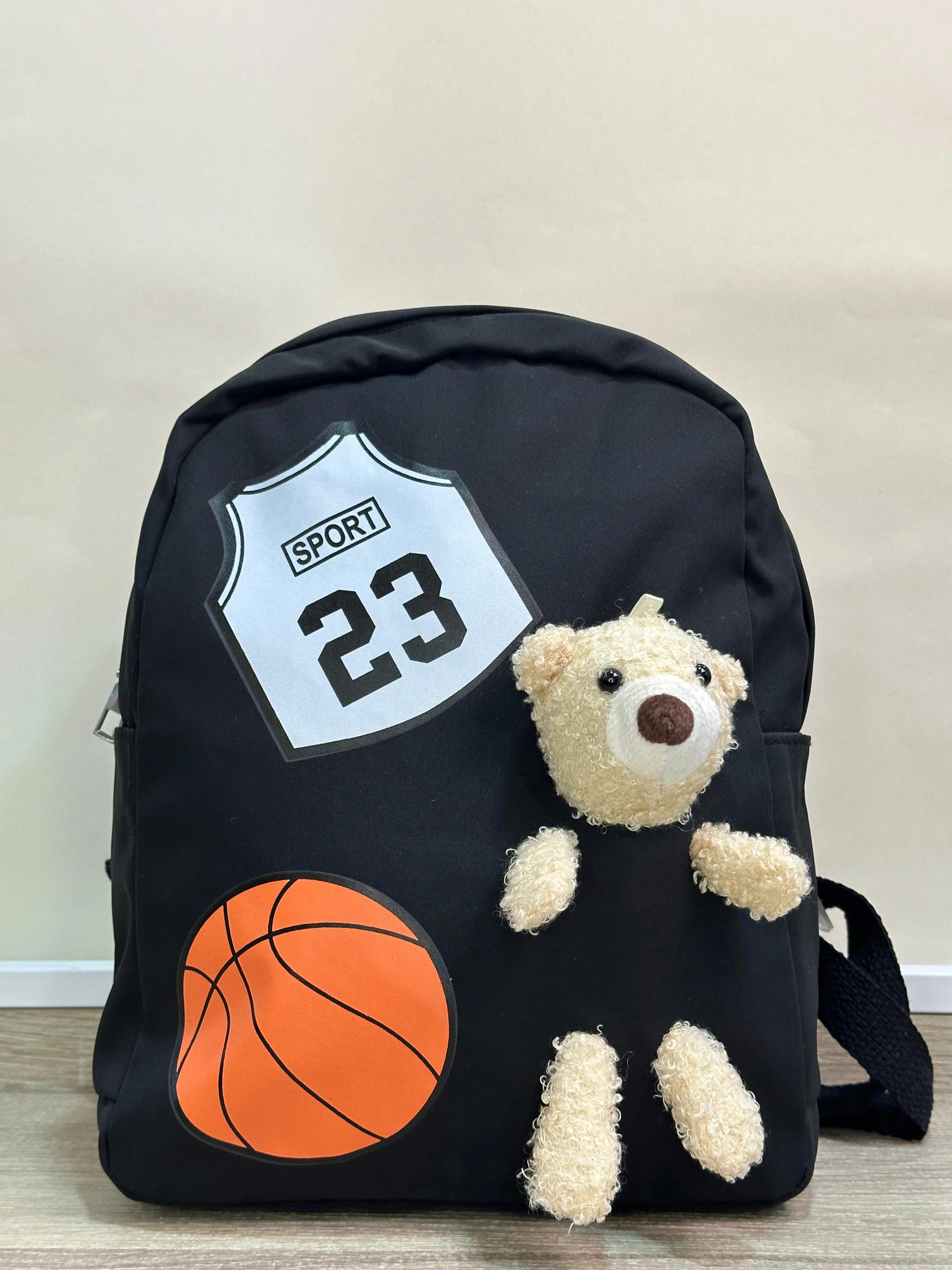 Mochila escolar negra con apliques de oso peluche, balón de baloncesto y diseño deportivo "SPORT 23".