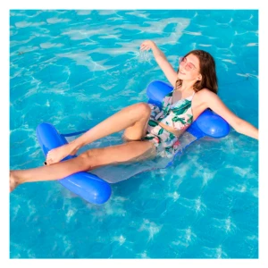 Hamaca flotador azul doble cara para piscina, mujer en traje de baño floral disfrutando el agua.