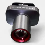 Linterna frontal metálica oscura, modelo Nanotec NT-L3185, con lente y aro rojo brillante.