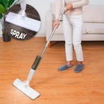 Trapeador con spray 360 mopa, ideal para limpiar pisos de madera. Persona usando trapeador con contenedor transparente.