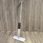Trapeador con spray 360, mopa blanca con botella café, mango plateado, ideal para pisos.