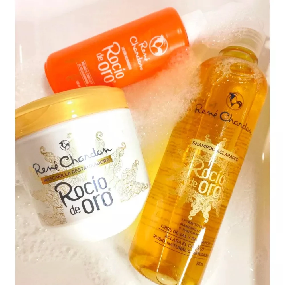 Kit aclarador Rocio de Oro: shampoo 500ml, mascarilla restauradora y loción, dispuestos sobre espuma para el cuidado y aclarado gradual del cabello.