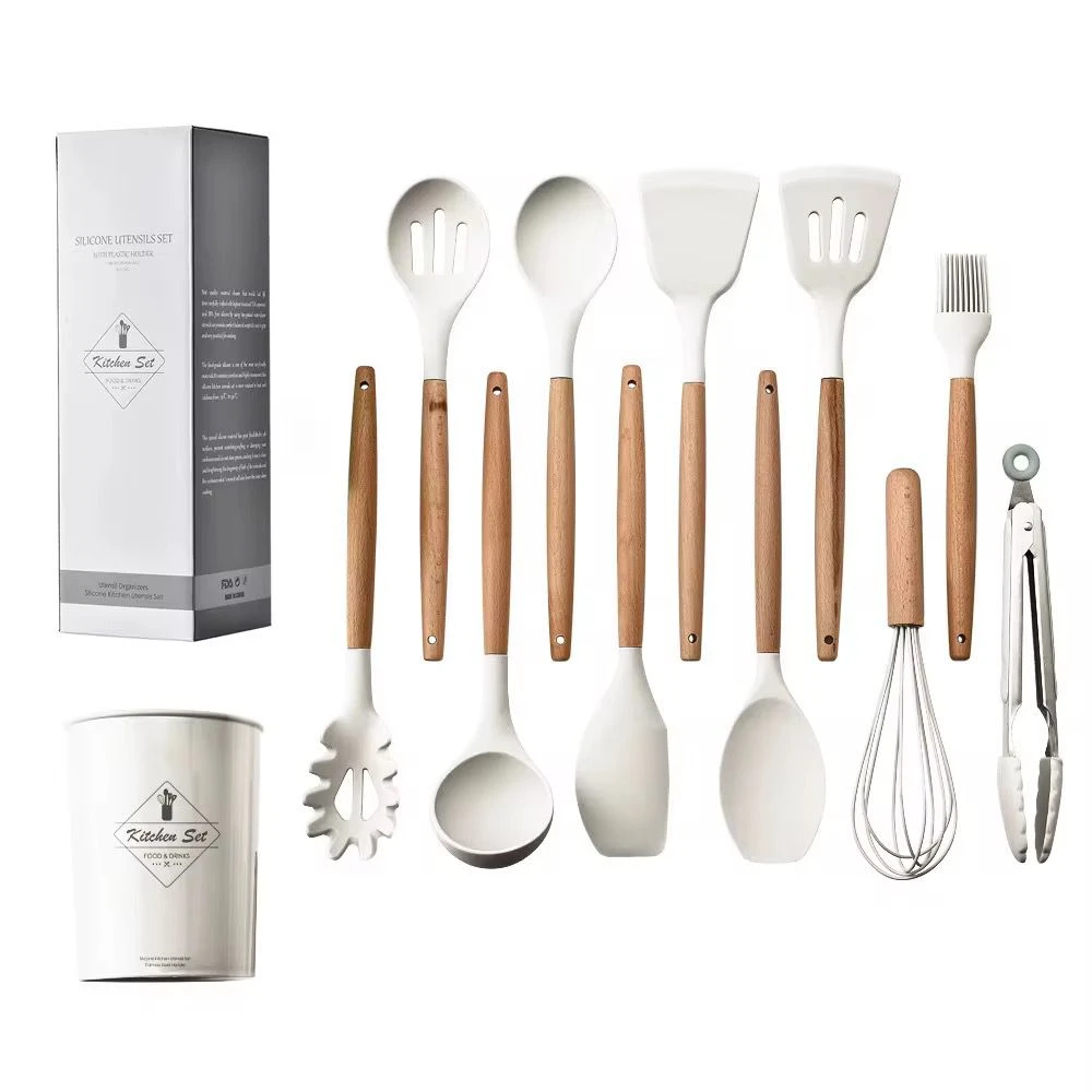 Set de 12 utensilios de cocina en silicona blanca con mangos de madera, incluye espátulas, cucharones, batidor, pinzas, envase organizador y su caja.
