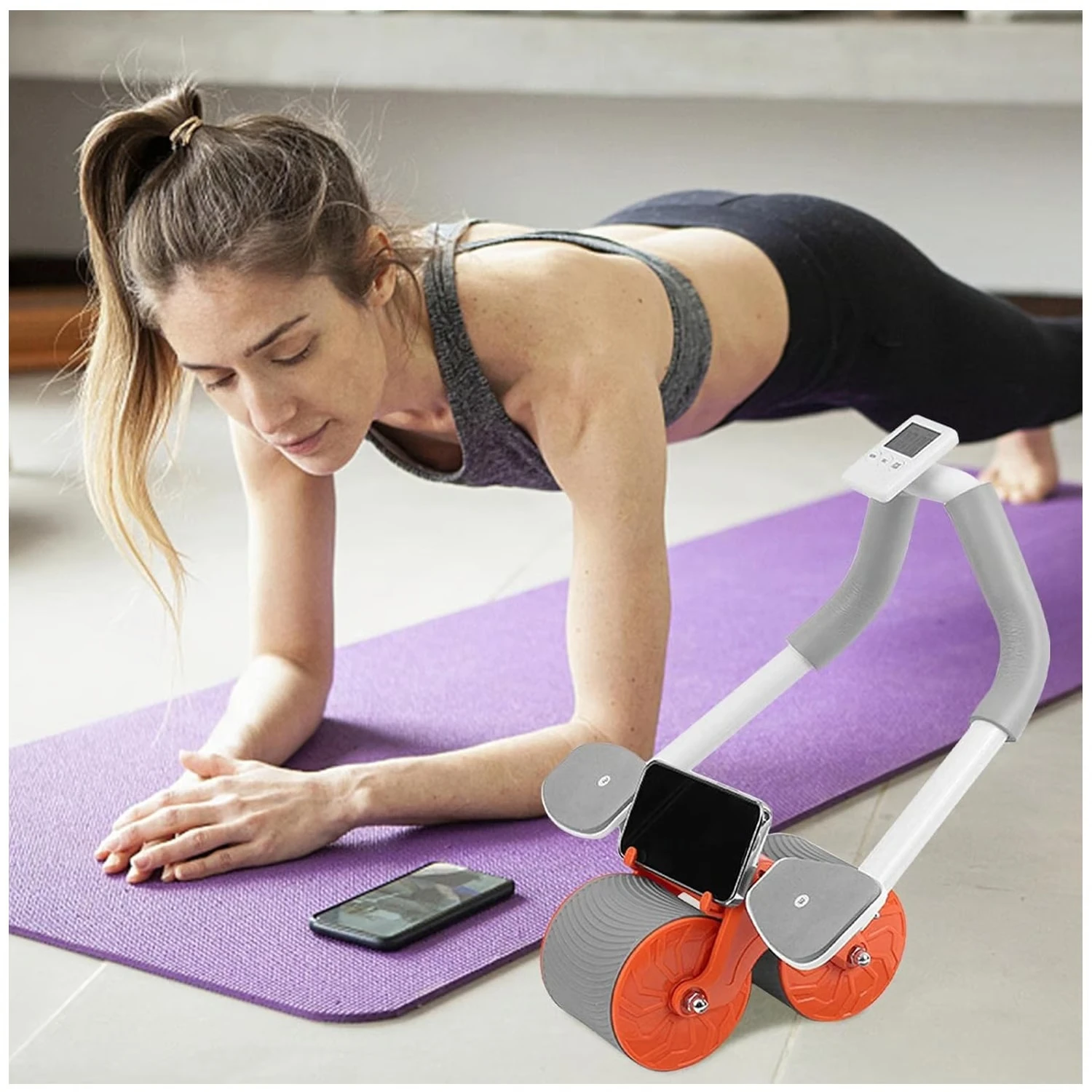 Mujer en plancha sobre tapete morado con rodillo ab-wheel naranja y gris, móvil en soporte.