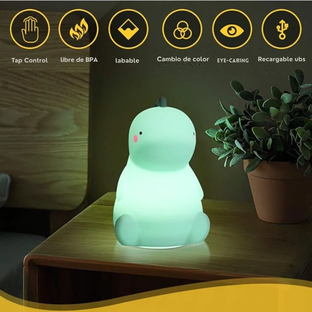 Lámpara nocturna de silicona suave en forma de dinosaurio verde iluminado sobre una mesa de noche, con iconos superiores de funciones táctiles y carga USB.