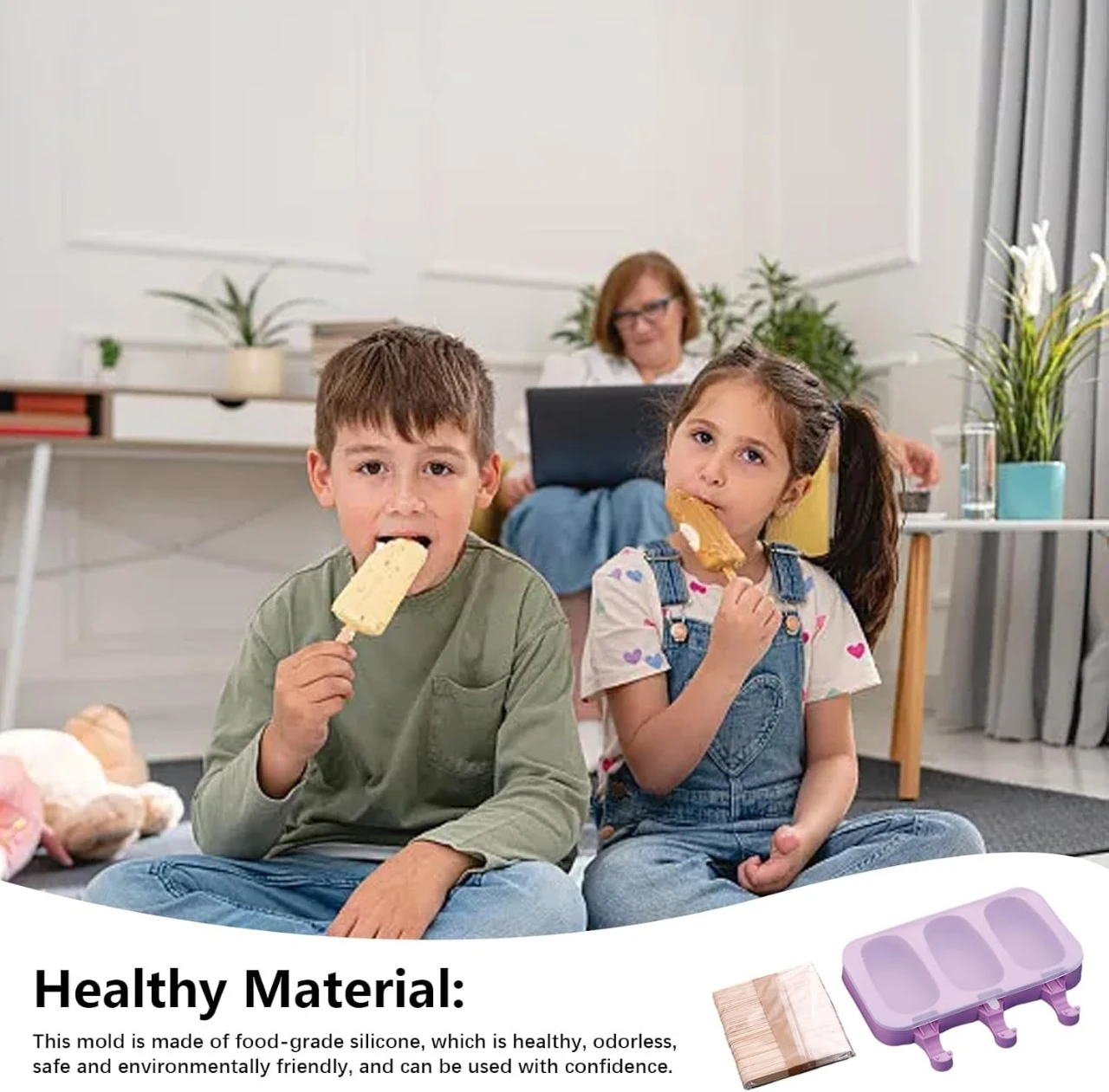 Niños comiendo paletas de helado caseras. A la derecha, molde de silicona morado para tres helados con tapa y paquete de palos de madera para helados.