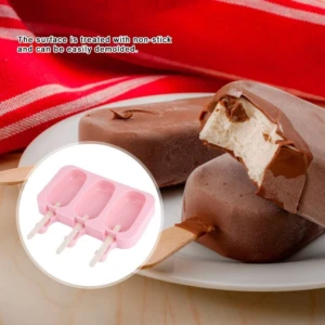 Molde de silicona rosado con tres cavidades para paletas, diseño antiadherente para desmoldar fácilmente, junto a paletas de chocolate caseras terminadas.