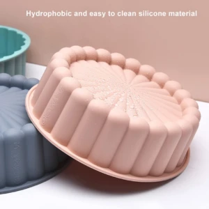 Moldes de silicona antiadherente para repostería en colores rosa y gris con diseño acanalado circular, material hidrofóbico y resistente al calor.