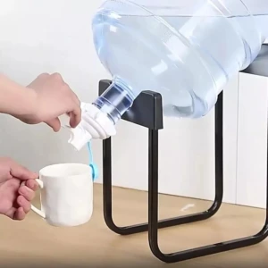 Soporte dispensador negro para botellón de agua, con llave blanca vertiendo agua a taza.