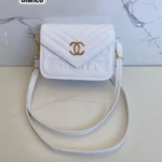 Cartera Chanel blanca con logo dorado y textura acolchada, estilo bandolera.