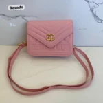 Cartera rosa pastel "Mani Chanel" con logo dorado y textura chevron, ideal para llevar cruzada.