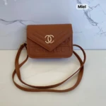 Cartera marrón "Miel" tipo Chanel con logo dorado, relieve "CHANEL" y correa cruzada.