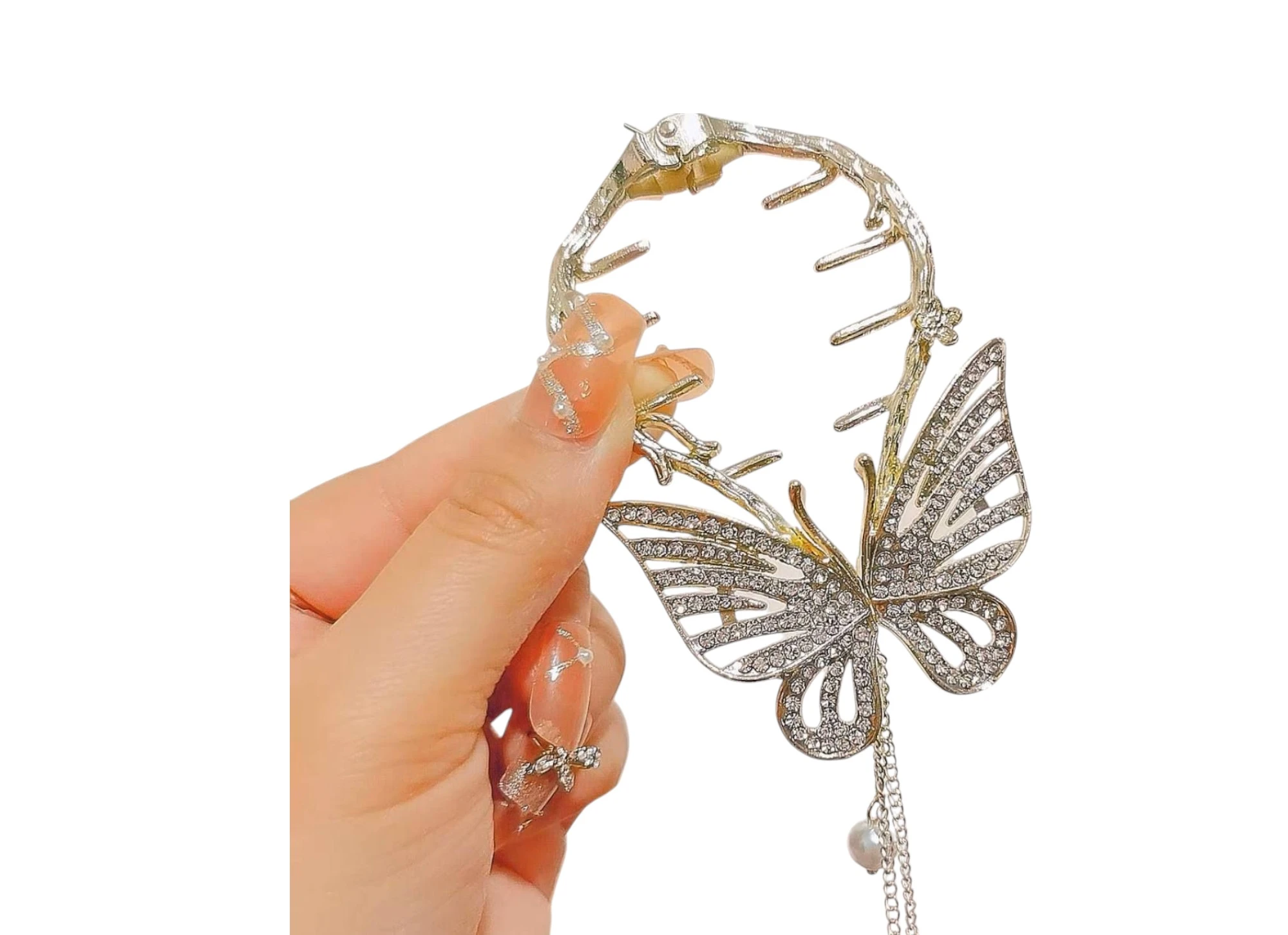 Pinza de cabello dorada con mariposa y pedrería, detalle de perla colgante.