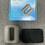 Anillo masajeador corporal gris y cinturón negro sobre fondo gris texturizado.