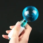 Bola de hielo facial azul para masaje con mango texturizado blanco.