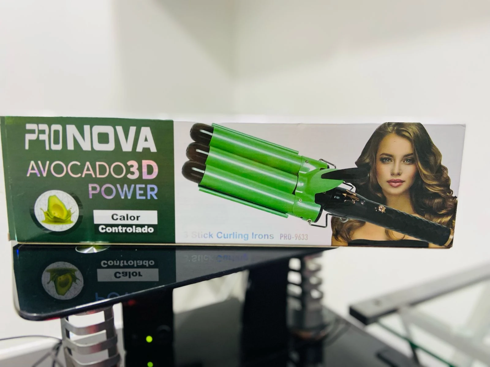 Ondulador de sirena Pro Nova verde de tres barriles con tecnología de calor controlado sobre caja exhibidora con publicidad de peinado ondulado.