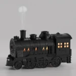 Humidificador de aire negro con forma de tren de vapor, emite vapor por chimenea.