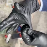 Manos vistiendo guantes de nitrilo negro texturizados, mostrando su elasticidad y ajuste.