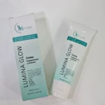 Crema despigmentante Lumina Glow de 70 ml junto a su caja, en envase blanco con detalles azul turquesa, diseñada para aclarar y unificar el tono de piel.