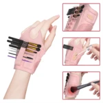 Guante rosa para maquillador con compartimentos para brochas y textura de limpieza.