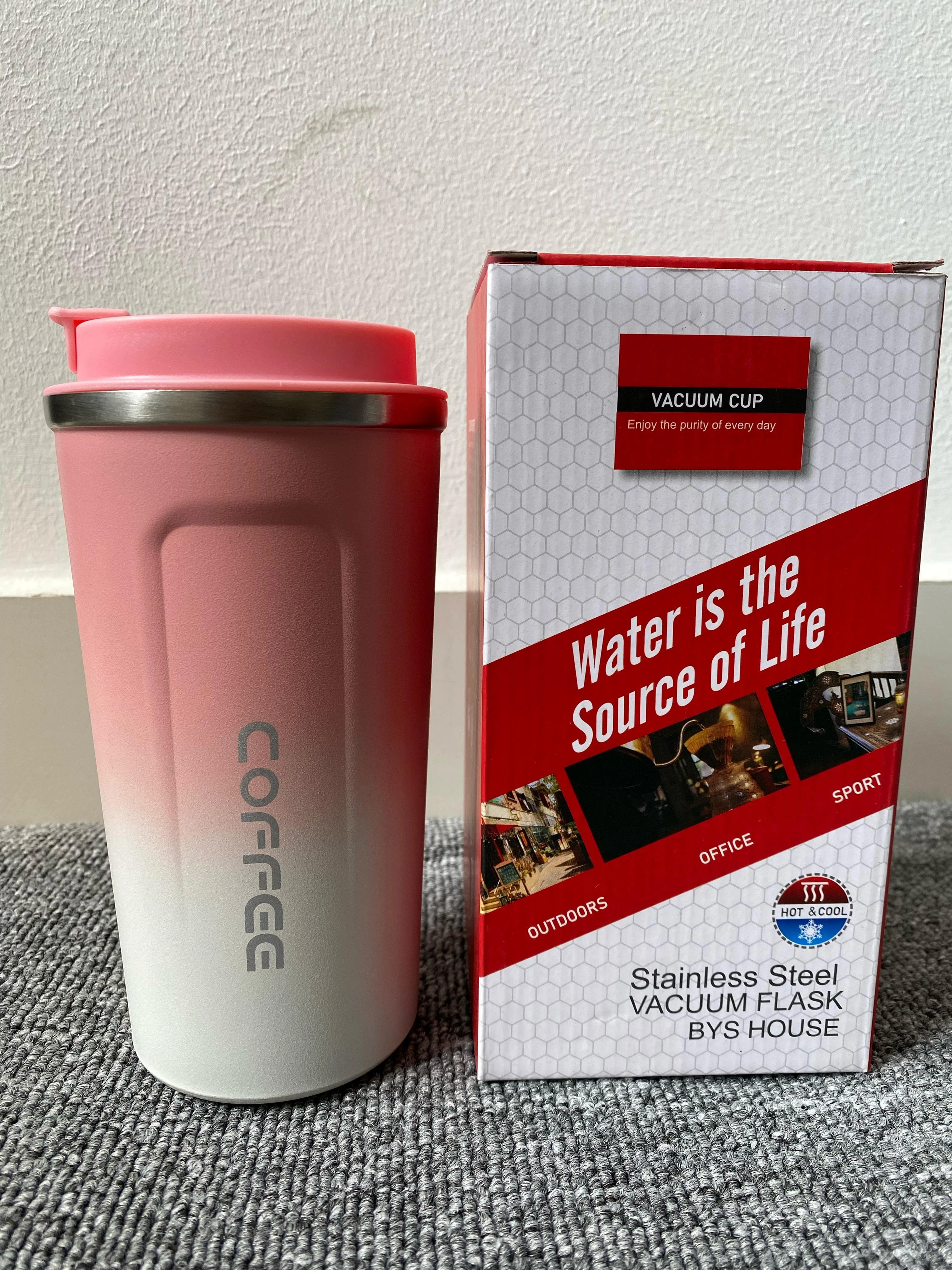 Vaso termo de acero inoxidable color rosa degradado a blanco, junto a su caja con frases motivacionales.