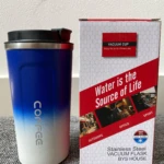 Vaso termo azul y blanco con texto "Coffee", junto a su empaque rojo y blanco.