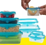 Juego de contenedores herméticos transparentes con tapas de silicona elástica azul, mostrando alimentos frescos almacenados y su apilado eficiente.