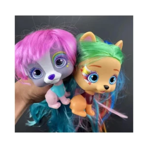 Dos muñecas tipo mascota VIP con cabello largo y colorido, una con pelo rosado y otra con pelo verde, sostenidas por una mano sobre fondo negro.