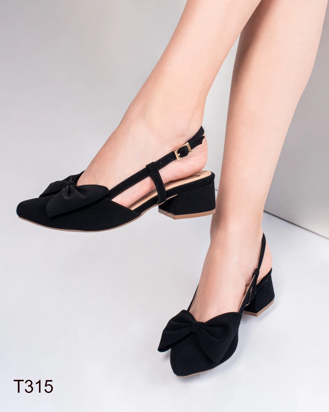 Zapatos de tacón bajo cuadrados para mujer en gamuza negra con cierre de hebilla, estilo destalonado y detalle de lazo frontal decorativo.