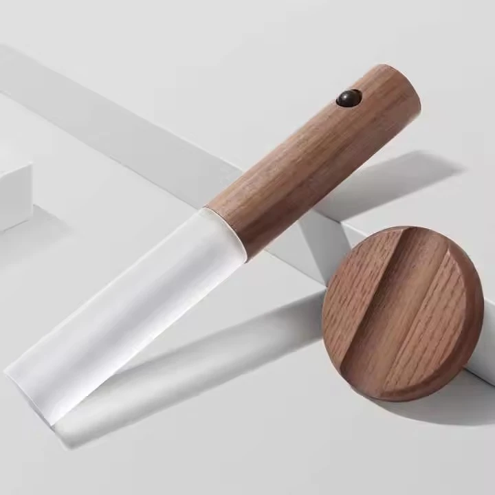 Lámpara portátil LED de diseño minimalista con cuerpo en madera oscura, difusor traslúcido y base circular de soporte a juego sobre fondo neutro.