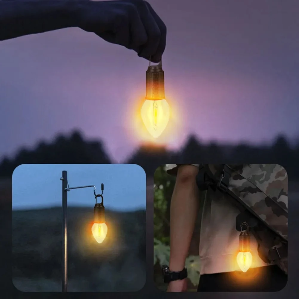 Lámpara de camping LED portátil con luz cálida tipo filamento, diseño metálico, gancho de sujeción para colgar en soportes o equipo de senderismo.