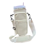 Estuche de neopreno color crema para termo Stanley, con bolsillo frontal con cremallera y correa ajustable.