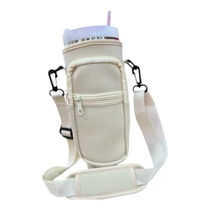 Estuche de neopreno color crema para termo Stanley, con bolsillo frontal con cremallera y correa ajustable.