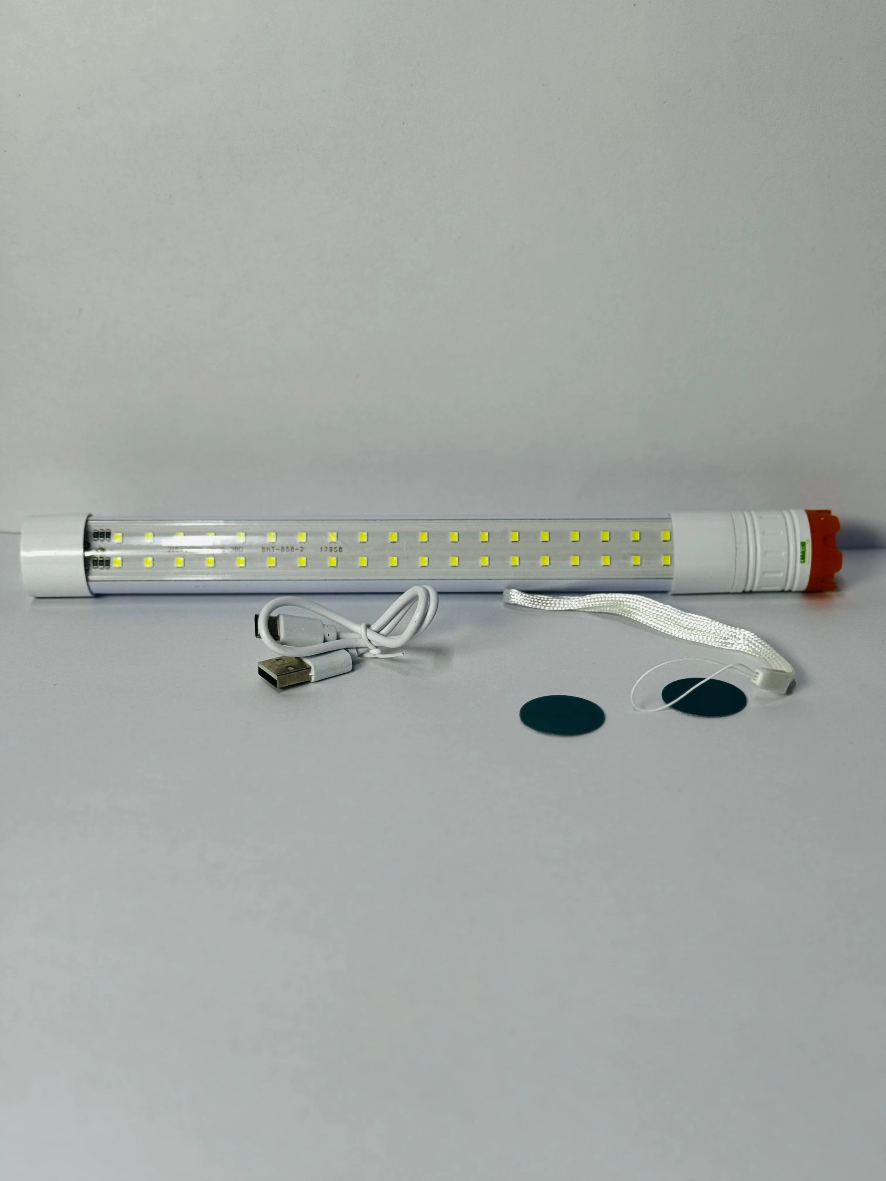 Linterna LED tubular blanca de 27cm con cable USB, cuerda y discos adhesivos.