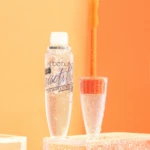 Set de dos serums transparentes para pestañas Kj Beauty con biotina, uno abierto mostrando aplicador de silicona naranja sobre base de acrílico con gotas.